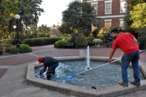 two men cleaning a fountain on UGA campus